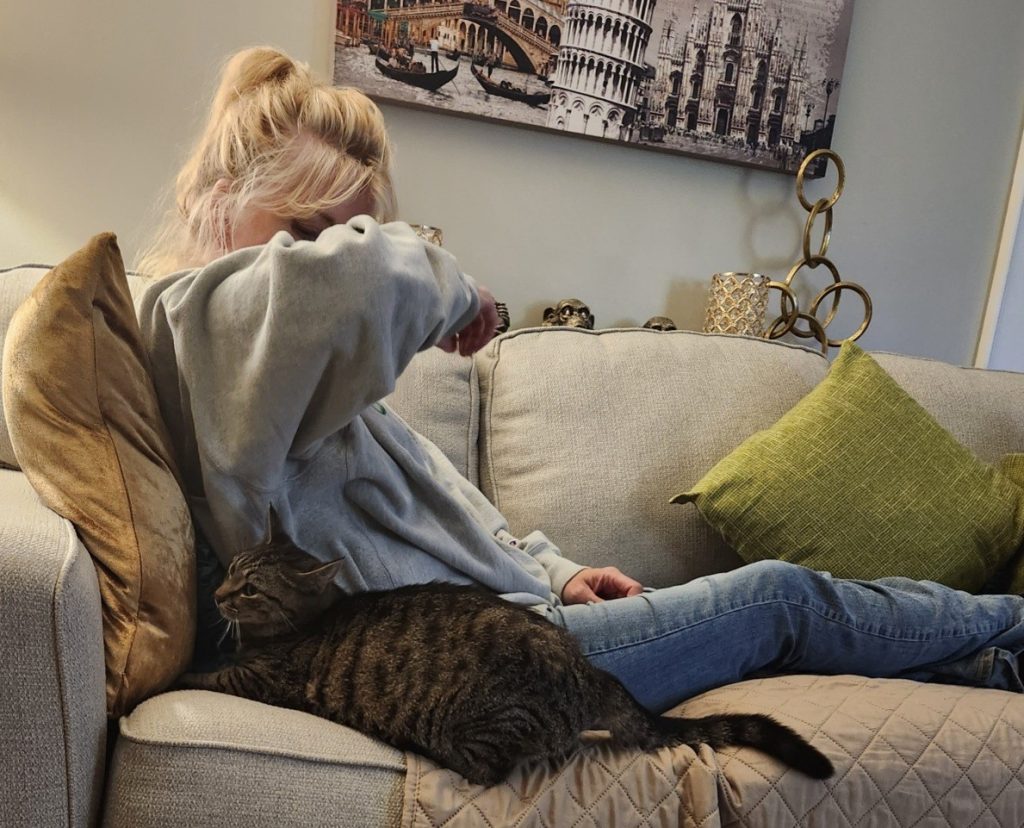 cat lying beside woman